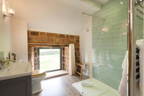 ein Badezimmer mit Toilette und Glasdusche in der Unterkunft Rocking Stone Cottage in Matlock
