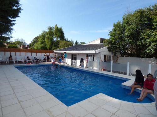 ein Schwimmbad mit Leuten, die um ihn herum sitzen in der Unterkunft Hotel Pinar del Lago in Villa Carlos Paz
