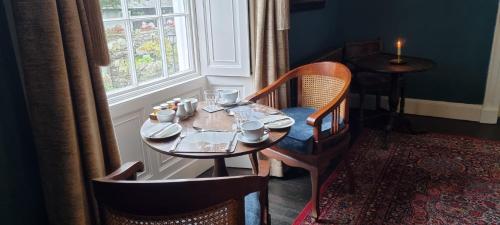 a table and chairs in a room with a window at Ivy Guest house in Hawkshead