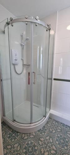 a shower with a glass door in a bathroom at Ivy Guest house in Hawkshead