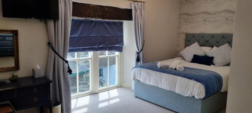 a bedroom with a bed and a large window at Ivy Guest house in Hawkshead