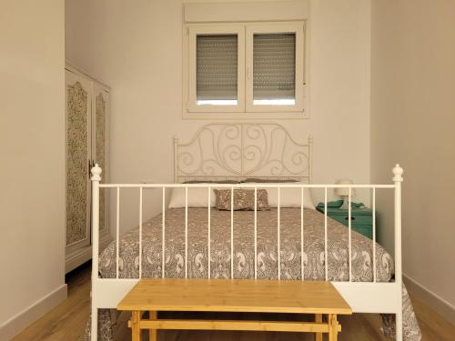 a white bed in a room with a window at Apartamento con WiFi y aparcamiento privado in Alcalá de Guadaira
