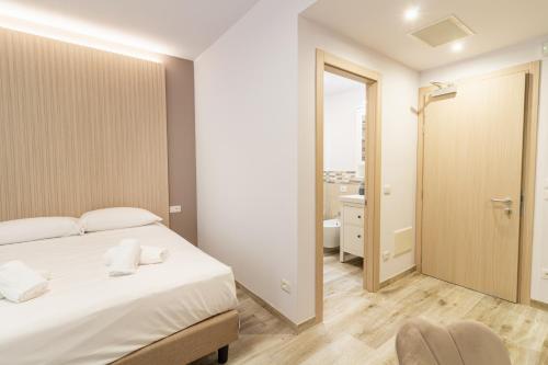 ein Schlafzimmer mit einem Bett und ein Badezimmer in der Unterkunft I Campi Wine Relais in Ronchi