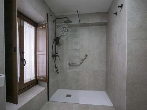 a bathroom with a shower with a glass door at La Casa Amarilla apartamento Albarracin in Albarracín
