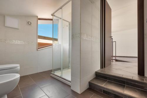 Un baño con inodoro y ducha de cristal. en Villa Belvedere Relais by Perle di Puglia, en Maruggio