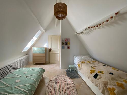 - une chambre mansardée avec un lit et un escalier dans l'établissement Mas Colorelle, à Puy-lʼÉvêque