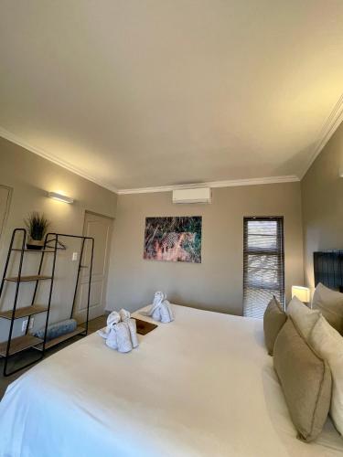 a bedroom with a large white bed with towels on it at The Baobab Bush Lodge and Villa in Hoedspruit