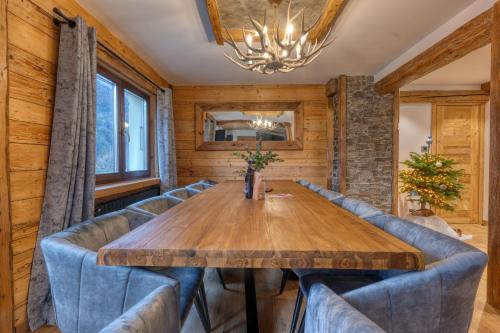 une salle à manger avec une table en bois et des chaises bleues dans l'établissement *Nouveau* Chalet Chamonix Cottage, à Chamonix-Mont-Blanc