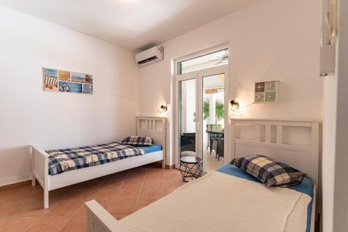 sypialnia z 2 łóżkami i drzwiami na patio w obiekcie Apartman GREEN & BLUE w Novalji