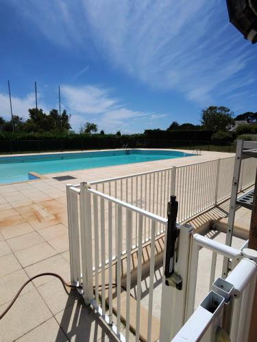une clôture blanche à côté d'une piscine dans l'établissement Appartement avec vue mer, à Arzon