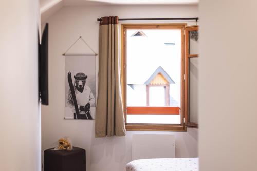 a bedroom with a window with a picture of a man at Le Rioumajou 1 - Grand T6 - Piscine - Centre St Lary in Saint-Lary-Soulan