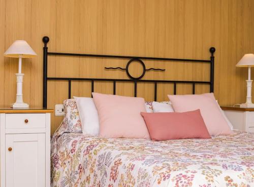 a bed with pink and white pillows and two lamps at Little Venice apartment in Alboraya