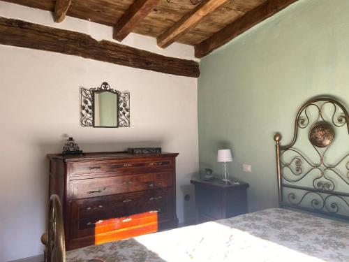 a bedroom with a bed and a dresser and a mirror at PRIMA DEL CIELO - appartamento MONTI in Esino Lario