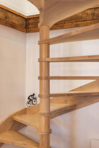 a wooden spiral staircase in a room with white walls at Le Rioumajou 1 - Grand T6 - Piscine - Centre St Lary in Saint-Lary-Soulan