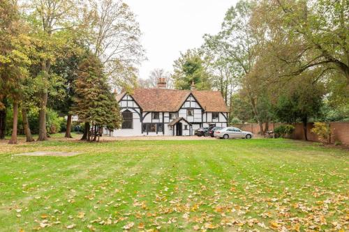 a house with a green lawn in front of it at Dorney Windsor Legoland 5 Star Stay for upto 14 guests in Dorney