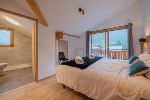 une chambre avec un grand lit et une salle de bain dans l'établissement Chalet Chinook, à Morzine