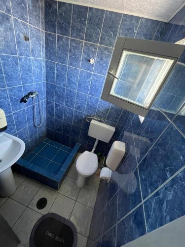 a blue tiled bathroom with a toilet and a sink at Hotel Capu' Turcului in Eforie Sud