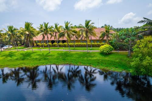 a resort with palm trees and a body of water at Club Palm Bay in Marawila