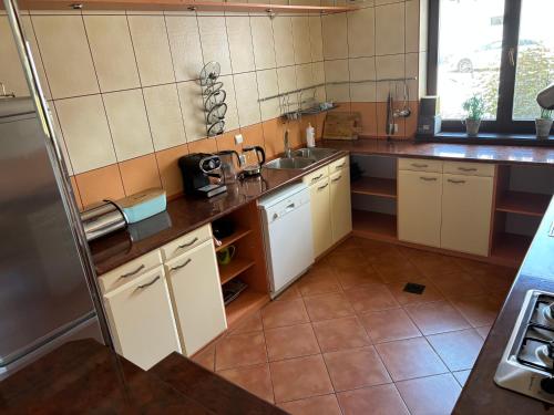 a large kitchen with white cabinets and a sink at Ranczo Pindorówka in Sorkwity