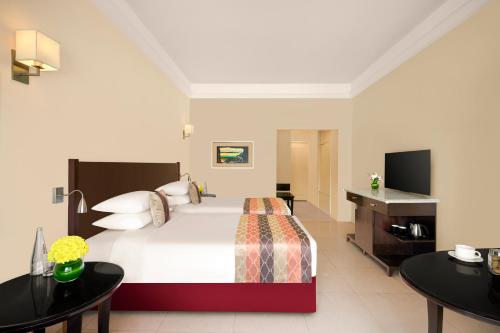 a bedroom with a large bed and two tables at Gateway Aurangabad - Chhatrapati Sambhaji Nagar in Aurangabad