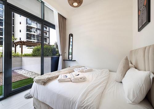 a bedroom with a bed with towels on it at 1BR Gem with Pool 15 Mins to Downtown Dubai in Dubai