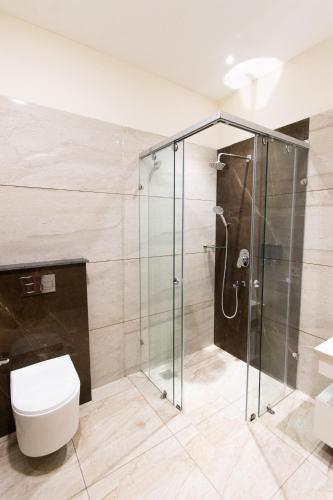 a bathroom with a shower and a toilet at Dyal Resorts in Phagwāra