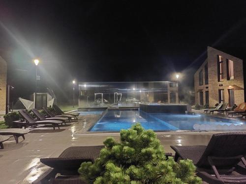 a swimming pool at night with chairs and a building at SeasideSpa appartment Jakuzzi Swimming pool in Palanga