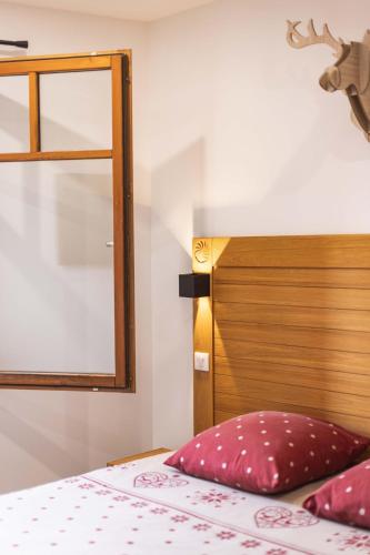 a bedroom with a bed with a wooden head board at Le Rioumajou 1 - Grand T6 - Piscine - Centre St Lary in Saint-Lary-Soulan