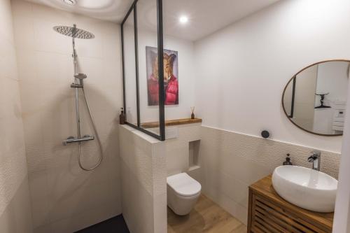 a bathroom with a sink and a toilet and a mirror at Le Rioumajou 1 - Grand T6 - Piscine - Centre St Lary in Saint-Lary-Soulan
