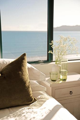 a bed with a window with a view of the ocean at Sunlit Bay Villas in Coopers Beach