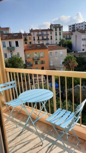 une table bleue et des chaises sur un balcon avec des bâtiments dans l'établissement Sunny Mercury - Room in Apartment, à Cannes