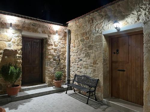 a bench sitting on a patio next to a wooden door at Traditional house Nikos in Roussokhória