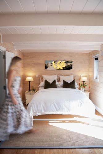 a woman walking through a bedroom with a bed at Sunlit Bay Villas in Coopers Beach