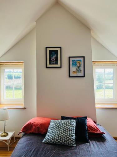 une chambre avec un lit avec deux tableaux au mur dans l'établissement La Maison Poésie, à Blay