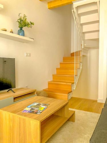 a living room with wooden stairs and a table at Viveiro Dreams in Viveiro