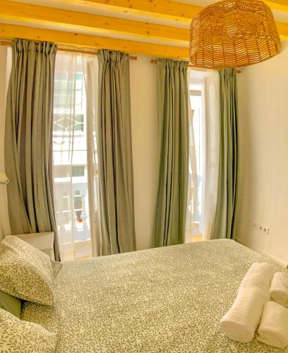 a bedroom with a large bed with green curtains at Viveiro Dreams in Viveiro