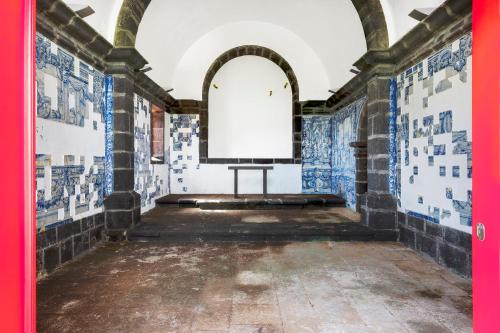 an empty room with blue and white tiled walls at Pousada Forte da Horta in Horta