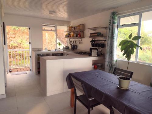 a kitchen with a table and a dining room table at Moorea - Atiha bay MH2 in Moorea