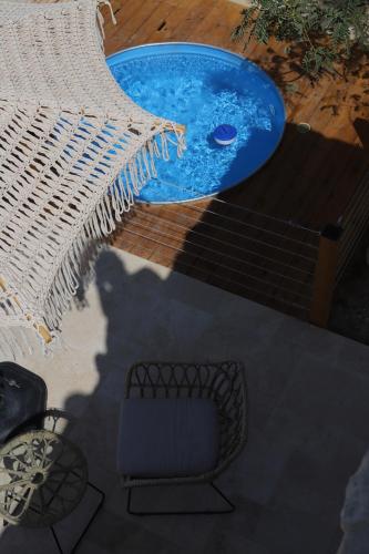 a hot tub with a table and a chair at אבן על הנחל in Merhav Am