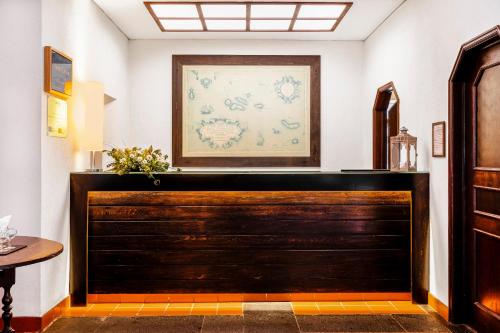 a large wooden door in a room with a picture on the wall at Pousada Forte da Horta in Horta