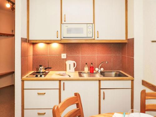 eine Küche mit Spüle und Mikrowelle in der Unterkunft Apartment Mont Fort 55 by Interhome in Siviez