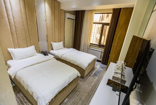 Postel nebo postele na pokoji v ubytování Firdavsi Hotel