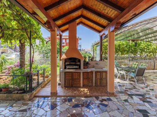 an outdoor kitchen with a pizza oven on a patio at Apartment Bumbak by Interhome in Umag