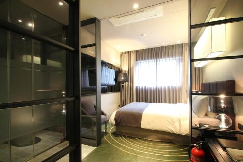 a hotel room with a bed and a window at Best Louis Hamilton Hotel Haeundae in Busan