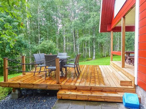 eine Holzterrasse mit einem Tisch und Stühlen darauf in der Unterkunft Holiday Home Pinea by Interhome in Niittymaa