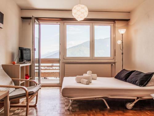 a bedroom with a bed and a large window at Apartment Valaisia 34A by Interhome in Nendaz