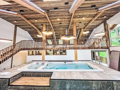 a large indoor swimming pool in a room with a wooden ceiling at Apartment Karlspitz by Interhome in Kleinsölk