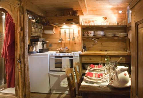a kitchen with a table and a stove top oven at Hôtel Les Chalets de Philippe avec Jacuzzis Privatifs in Chamonix-Mont-Blanc