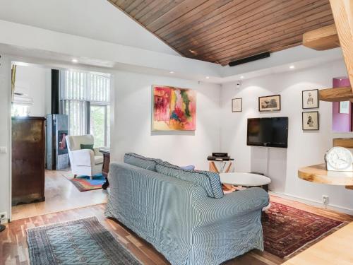 a living room with a blue couch and a tv at Chalet Rindö by Interhome in Vaxholm