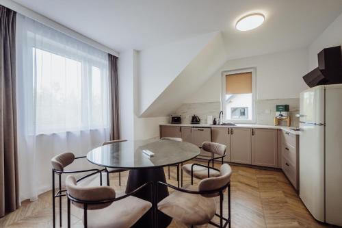 una cucina con tavolo, sedie e frigorifero di CristalView Stay&Relax - PROMOCJA ZAREZERWUJ 3 NOCE W CENIE 2!!! darmowe zewnętrzne jacuzzi, zwierzęta akceptowane a Podgórzyn